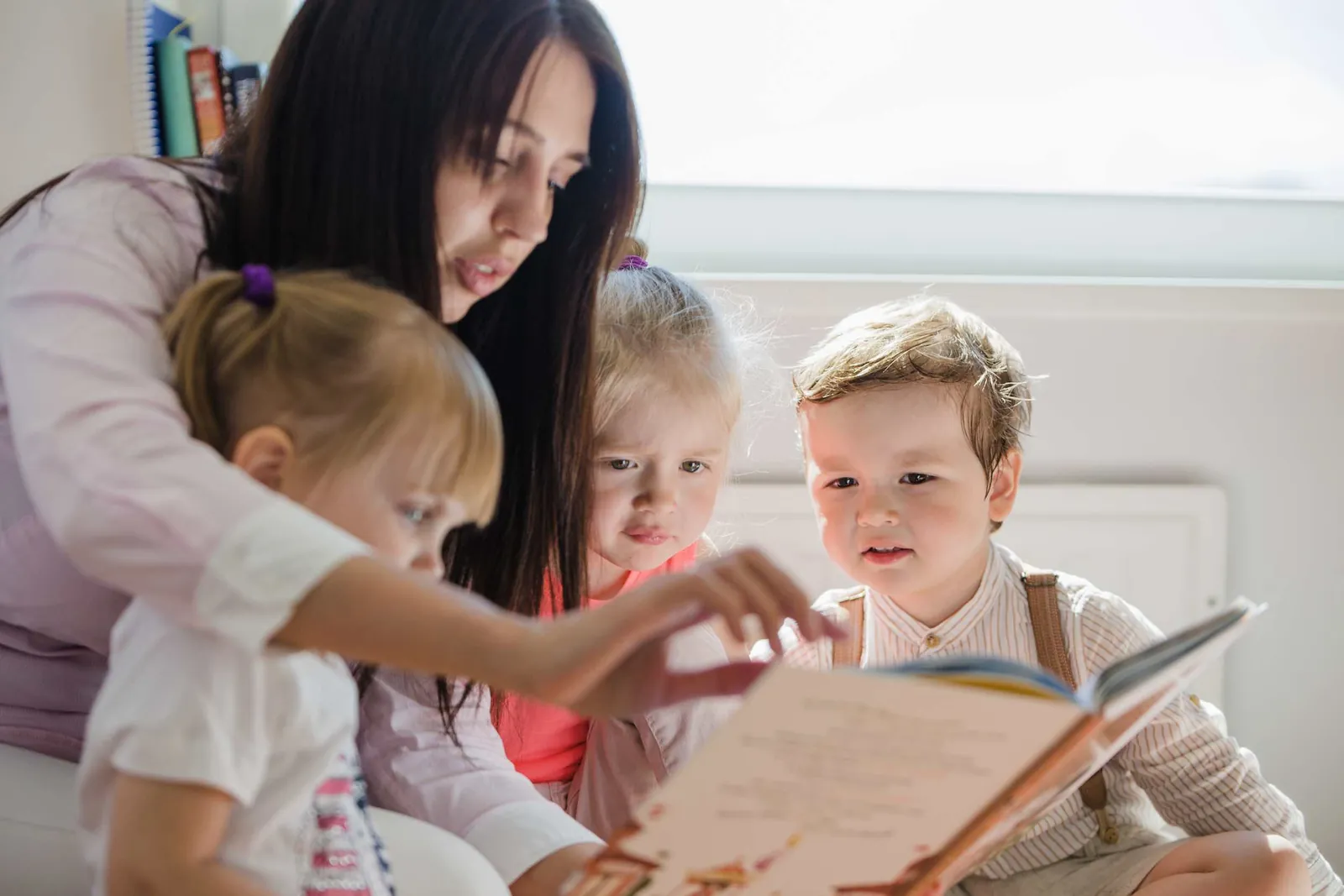 Élève lisant une histoire à de jeunes enfants