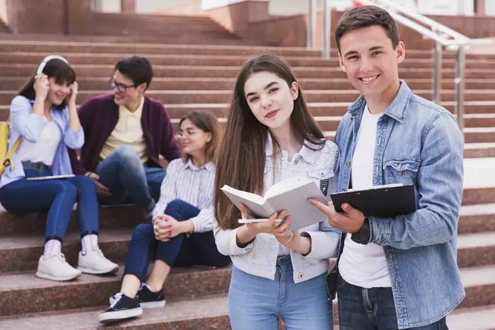 Groupe d'élèves souriants avec leurs cahiers